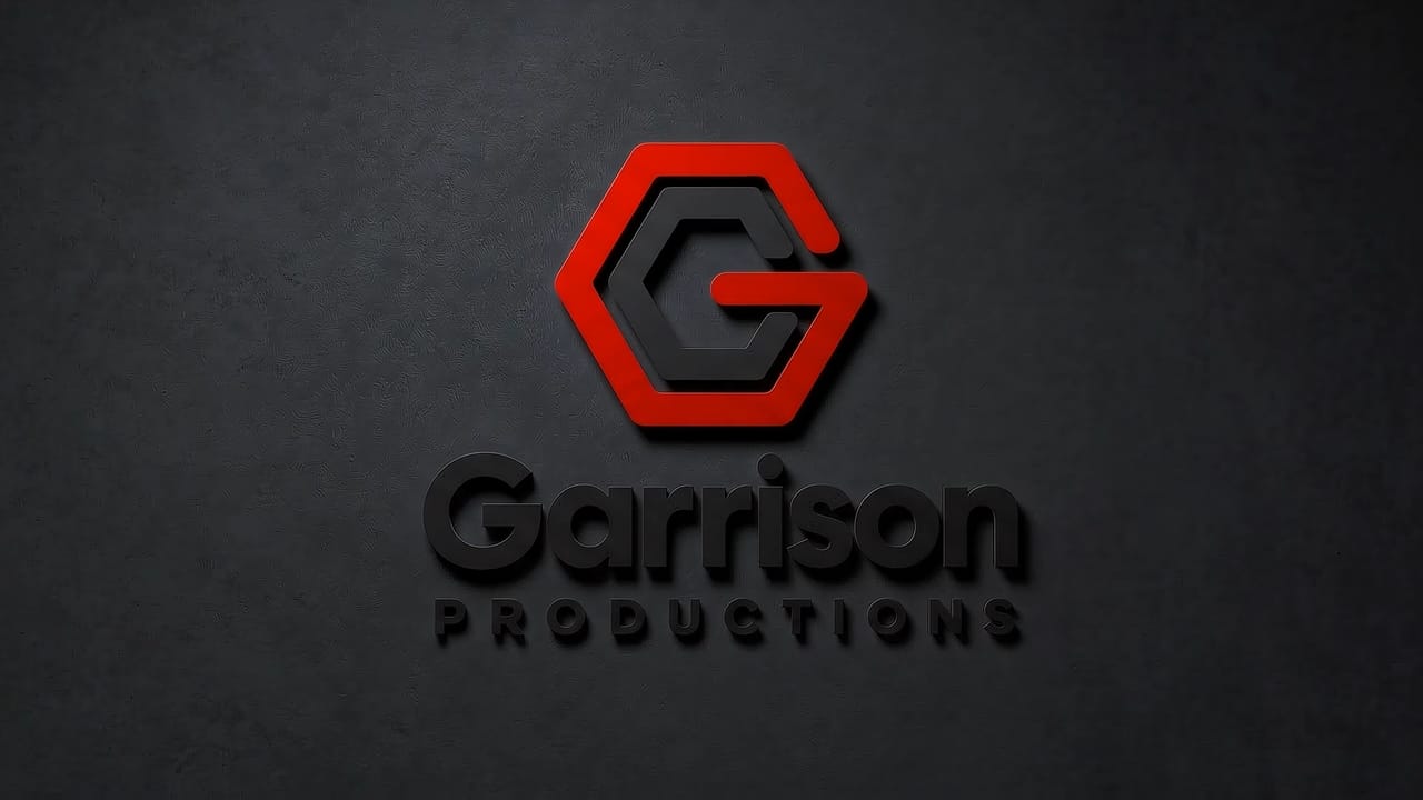 Garrison Productions backlit logo sign on a dark concrete wall, shown with the lights off