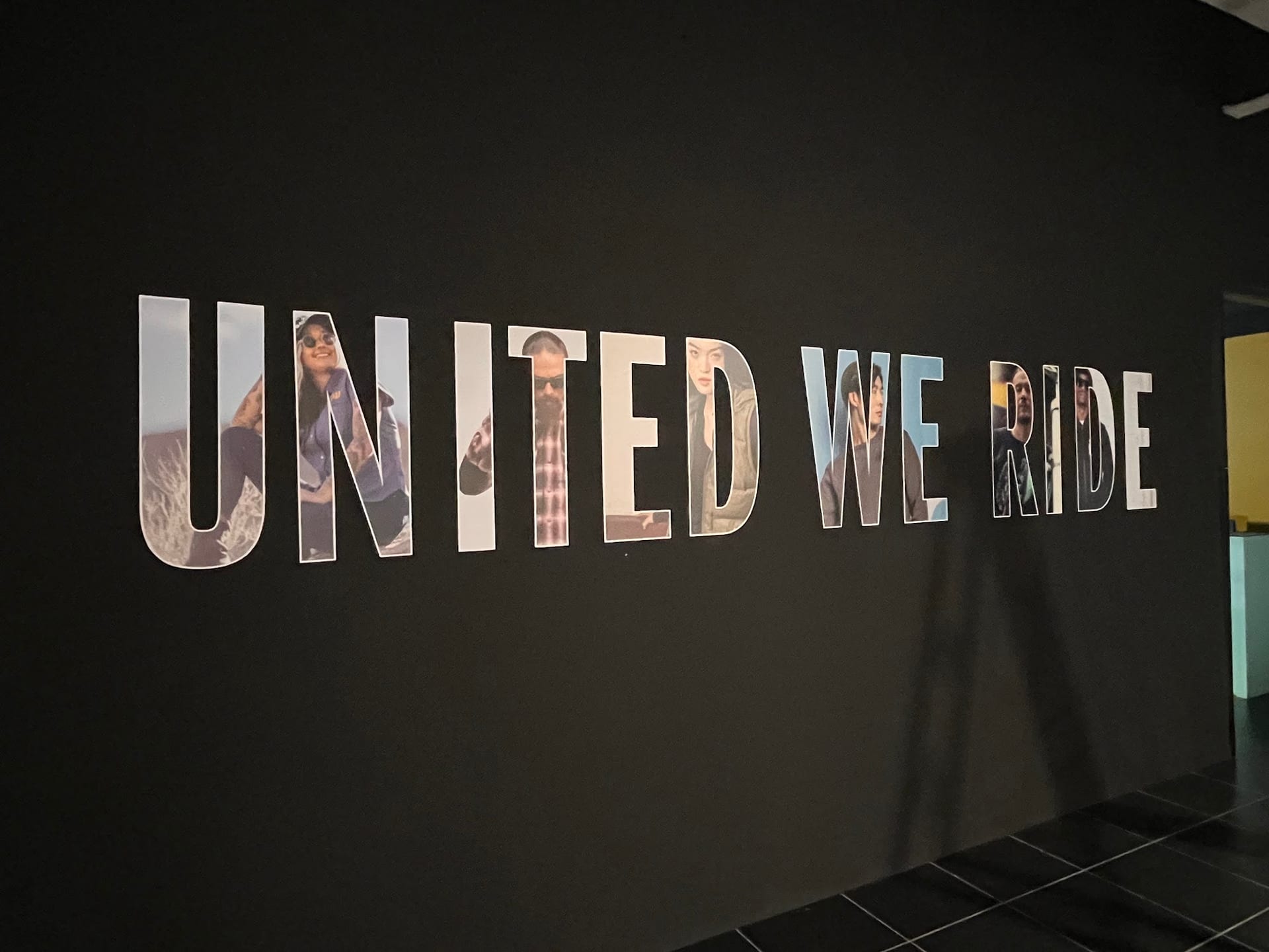 "United we ride" black hoarding with large lettering — Hoarding Sticker Printing by Garrison Productions, Singapore