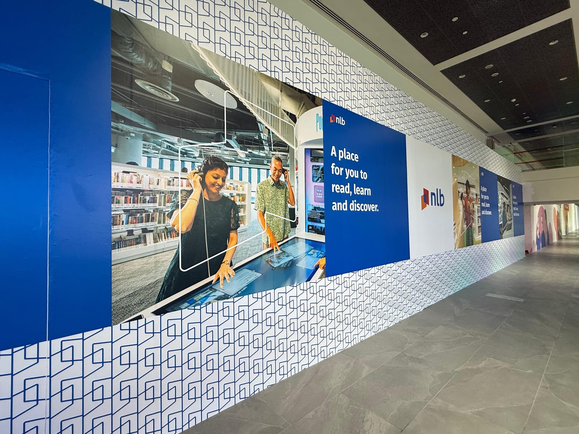 NLB library hoarding with people photography in a mall — Hoarding Sticker Printing by Garrison Productions, Singapore