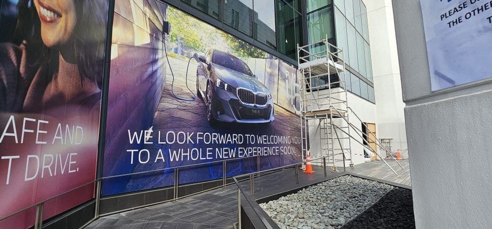 "We look forward to a whole new experience" car showroom hoarding — Hoarding Sticker Printing by Garrison Productions, Singapore