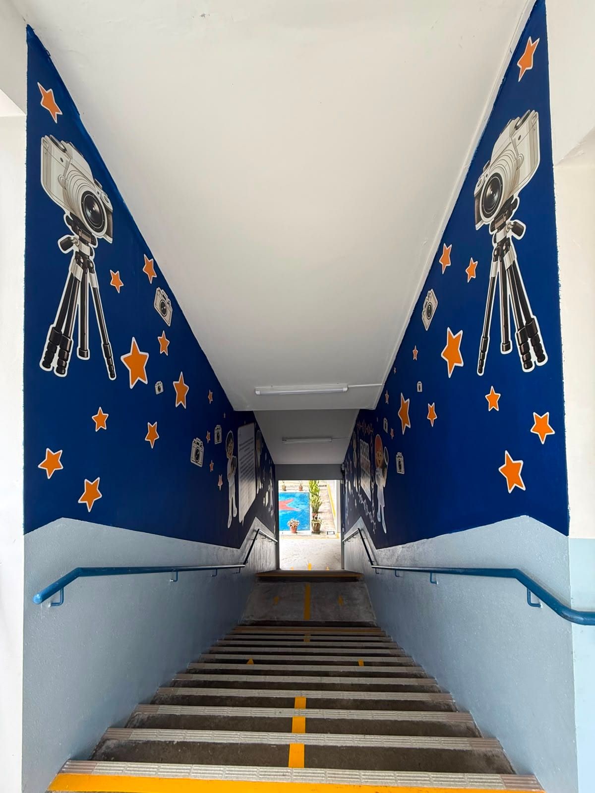 Star and rocket wall mural along a school staircase — Wall Mural by Garrison Productions, Singapore